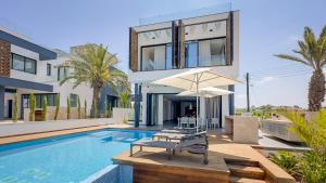 a villa with a swimming pool and a house at Sunrise Beachfront Villas - Villa 1 in Paralimni