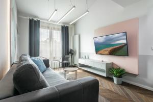 Premium Apartment in Kossak Residence في كراكوف: غرفة معيشة مع أريكة وطاولة