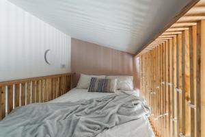 Premium Apartment in Kossak Residence في كراكوف: غرفة نوم بسرير مع جدار خشبي