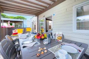 a table with plates of food on a patio at Camping Village Garden Paradiso in Cavallino-Treporti