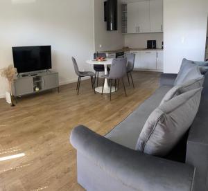 a living room with a couch and a table with chairs at Apartament Tęczowa in Gdynia