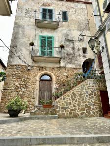 - un vieux bâtiment en pierre avec deux fenêtres et une porte dans l'établissement Appartamento del Pescatore, à Castellabate