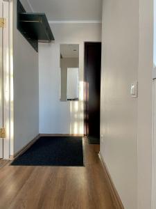 un pasillo vacío con una puerta y un espejo en Valdemāra apartamenti en Valmiera