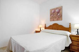 um quarto com uma cama branca e 2 candeeiros em Casa Soumia em Vejer de la Frontera