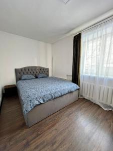 a bedroom with a bed and a large window at Valdemāra apartamenti in Valmiera