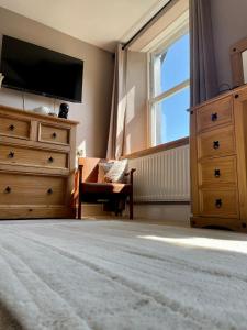 a bedroom with a dresser and a tv and a dresser with a window at The Mortal Man Inn in Troutbeck