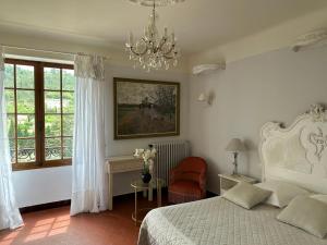 a bedroom with a bed and a chandelier at Hôtel du Moulin in Allemagne-en-Provence