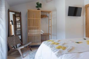 a bedroom with a bed and a chair and a mirror at Casa del Sol 55 in Cardeñadijo