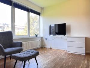 a living room with a chair and a flat screen tv at One Bedroom Apartment In Rdovre, Trnvej 33a, in Rødovre
