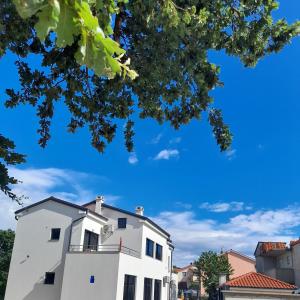 a white building with a blue sky in the background at IGGY in Malinska