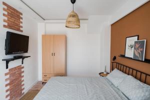 a bedroom with a bed and a flat screen tv at Le petit escape in Varna City