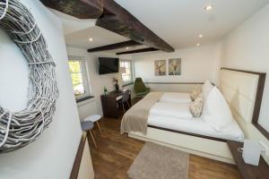 a bedroom with a bed and a desk in a room at Hotel zum Braunen Hirschen in Bad Driburg