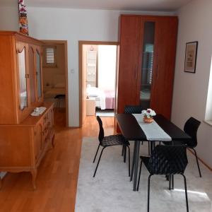 a living room with a table and chairs and a bedroom at Apartman Selce in Selce