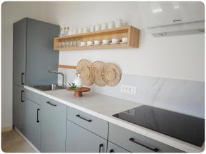 a kitchen with white cabinets and a sink at Modern Mediterranean Oasis - Villa Bolka in Bol