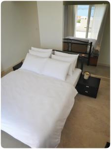 a large white bed with white sheets and pillows at Modern Mediterranean Oasis - Villa Bolka in Bol