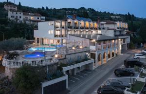 a large house with a swimming pool on a street at Hotel Tomi in Portorož