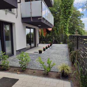 a garden with potted plants and a walkway at Apartamenty Amadeus Mare in Rowy
