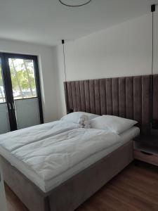 a bed with a teddy bear sitting on top of it at Apartamenty Amadeus Mare in Rowy