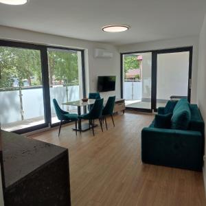 a living room with a couch and a table and chairs at Apartamenty Amadeus Mare in Rowy