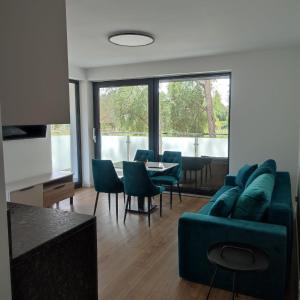 a living room with a couch and a table and chairs at Apartamenty Amadeus Mare in Rowy
