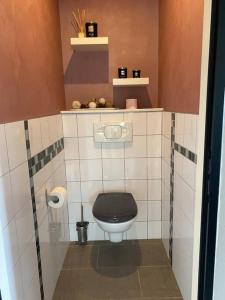 a small bathroom with a toilet with a black seat at L’atelier du Bois de Charbuy 