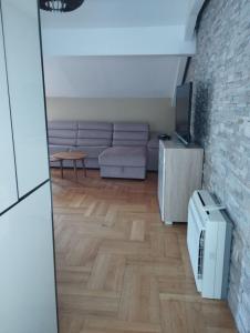 a living room with a couch and a tv at The Old Town Terrace Apartments in Budva