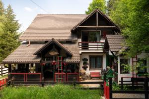 una casa con techo marrón y valla roja en Casa cu Amintiri, en Bran