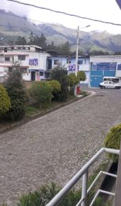 eine Straße mit Gebäuden und einem Auto auf einer Straße in der Unterkunft Casa campestre en las faldas del Taita Imbabura 3 in Otavalo