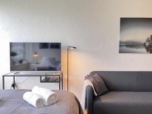 a room with a couch and a bed with towels at Studio Apartment In Rdovre, Trnvej 49d, 3 in Rødovre