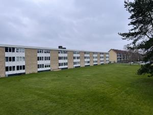 un grand bâtiment avec une pelouse devant lui dans l'établissement Studio Apartment In Rdovre, Trnvej 49d, 3, à Rødovre