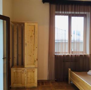 a bedroom with a wooden cabinet and a window at Honi in Ijevan