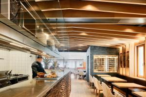 a man is preparing food in a restaurant kitchen at Hotel de l'Isard in Andorra la Vella