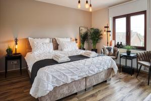 um quarto com uma cama grande e lençóis brancos em BnB Pastel em Dilsen-Stokkem