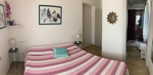 オルビアにあるPunta Sirenellaのベッドルーム(ピンクと紫のストライプのベッド1台付)