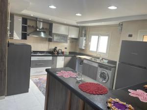 eine Küche mit Waschmaschine und Trockner auf der Theke in der Unterkunft شقة فندقية 3 غرف كمبوند الخمائل in Kafr Abū ʼumaydah