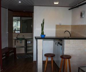 a kitchen with two stools and a counter with a sink at Toca da Tulipa in Paraty