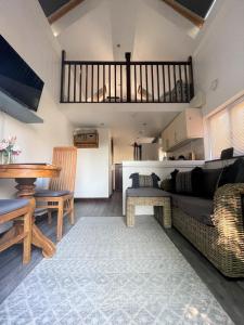 uma sala de estar com um sofá e uma mesa em The Stables - Detached Cottage with Private Garden & Hot Tub em St Austell