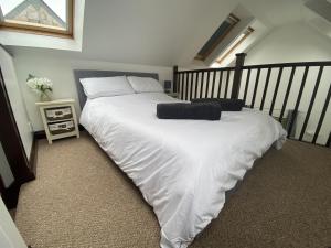 um quarto com uma grande cama branca num quarto em The Stables - Detached Cottage with Private Garden & Hot Tub em St Austell