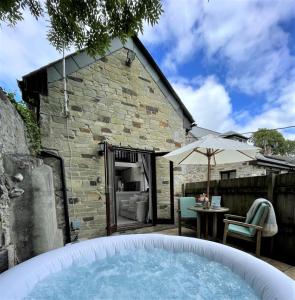 a hot tub in the backyard of a house at The Stables - Detached Cottage with Private Garden & Hot Tub in St Austell