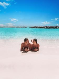 a man and a woman sitting on a beach at Curacao Avila Beach Hotel in Willemstad