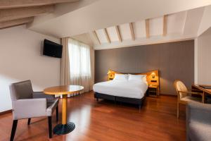 une chambre d'hôtel avec un lit et une table dans l'établissement Hotel de l'Isard, à Andorre-la-Vieille