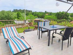 a patio with chairs and a table on a deck at Andrija Apartment in Krnica