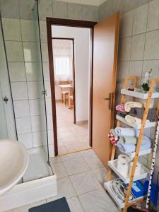uma casa de banho com um chuveiro, um lavatório e um espelho. em Andrija Apartment em Krnica