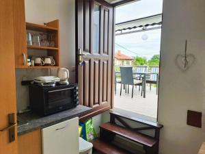 a kitchen with a door to a patio with a stove at Andrija Apartment in Krnica