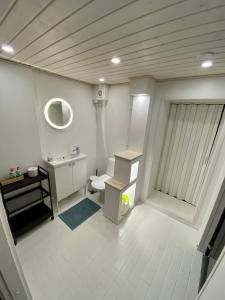 La salle de bains blanche est pourvue d'un lavabo et de toilettes. dans l'établissement Big Duplex, 15min to Turku or Naantali, à Turku