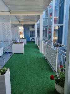 um corredor com um piso verde num edifício em Appart-Hotel Holiday em Lignano Sabbiadoro