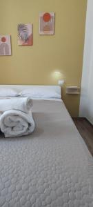 um quarto com uma cama grande e lençóis brancos em Petranova Affittacamere B&b em Agropoli