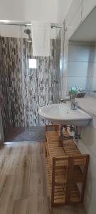 uma casa de banho com um lavatório e uma cabina de duche em vidro. em Petranova Affittacamere B&b em Agropoli