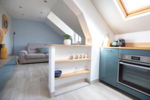 a kitchen with a blue oven and a living room at Modern apartement in the city center. in Poissy