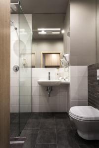 a bathroom with a toilet and a sink and a shower at Hotel Zatoka in Gdańsk